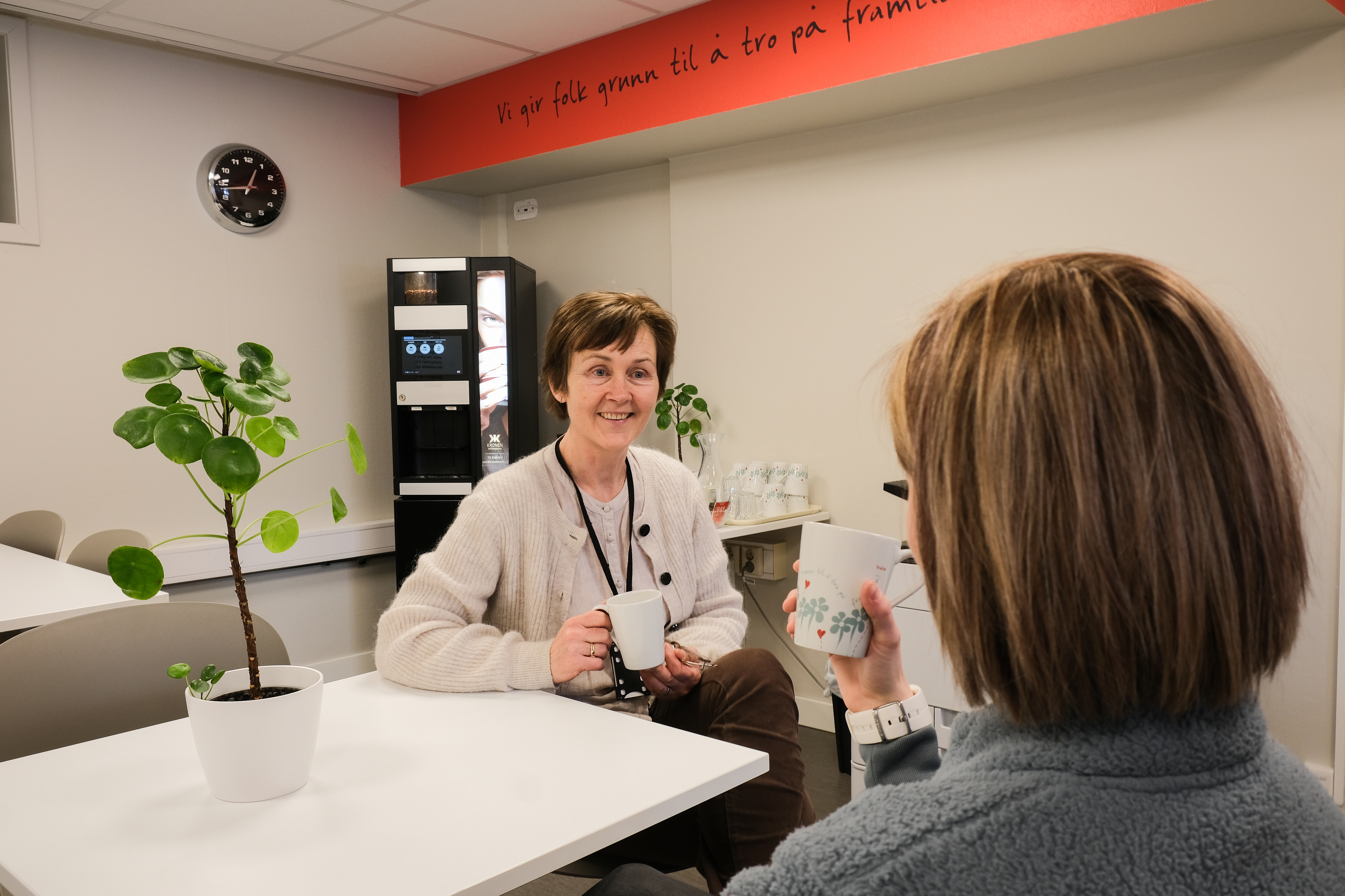 To som snakker sammen i en kantine